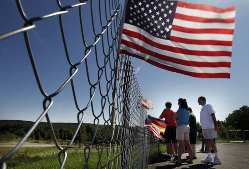 Visitors peer past the fence to the Flight 93 National Memorial, at the sacred ground of the Flight 93 crash site and the newly completed memorial in Shanksville, Pennsylvania on Friday afternoon, August 12, 2011. The memorial will open to the public on September 10. (Laurence Kesterson/Philadelphia Inquirer/MCT)