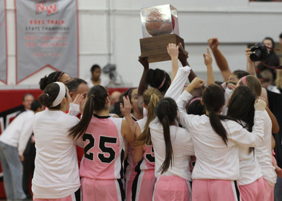 The girls basketball team holds up their trophy after their victory against Niles North. Photo by: Vicky Robles