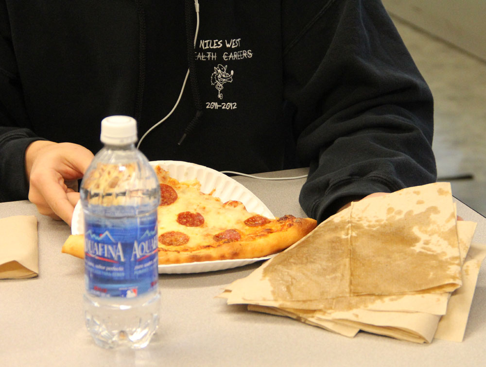 A student shows off grease from a slice of Organic Life pizza. PHOTO by Vicky Robles