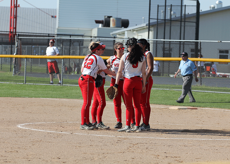 Last seasons girls varsity softball team gathering at the mound mid-game. 