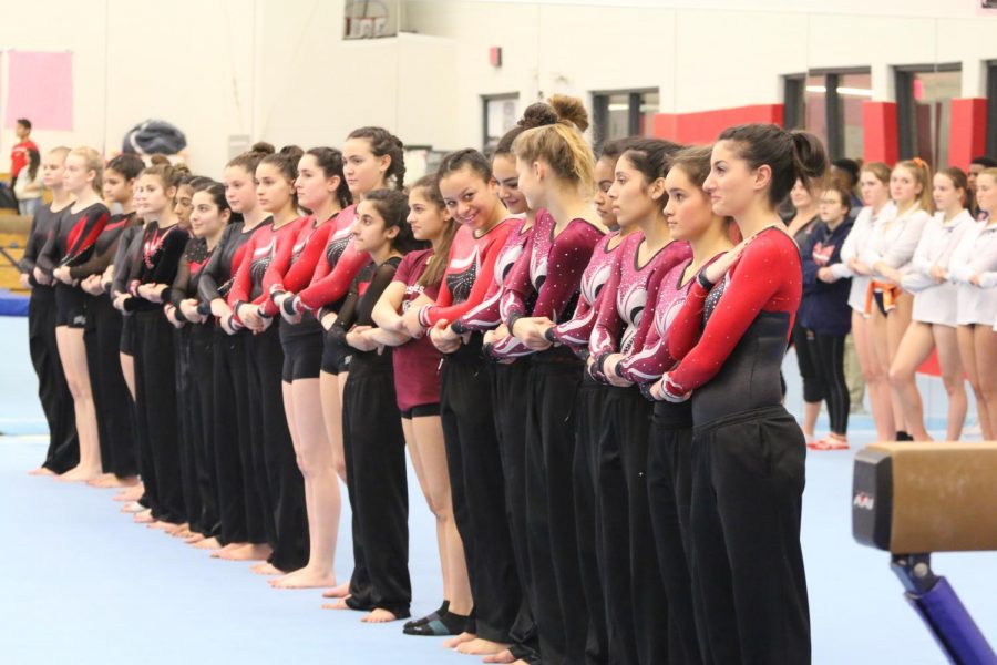 The varsity gymnastics team lines up for the National Anthem. 
