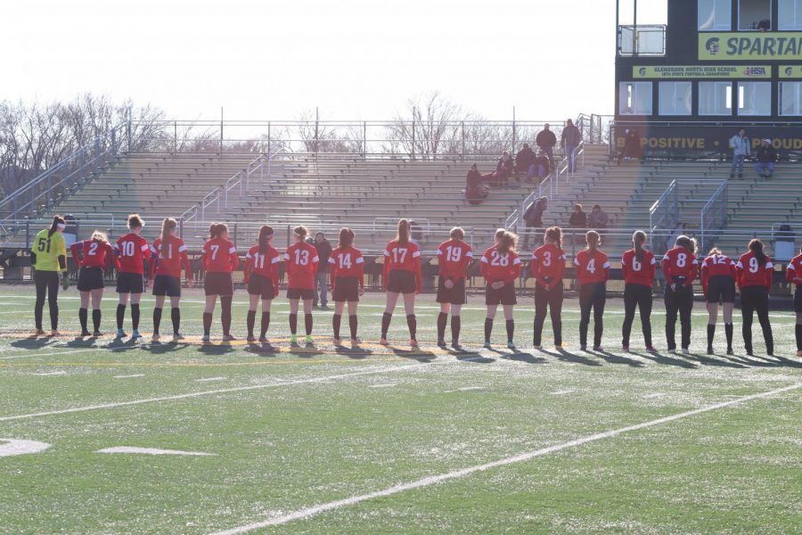 The girls varsity soccer team lines up for the National Anthem before their game. 