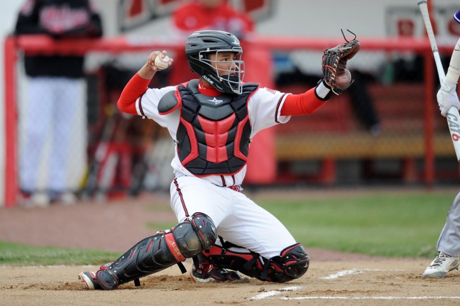 Mid-game%2C+catcher+Diego+Acosta+holds+the+ball+ready+to+throw+it+back+to+the+pitcher.+