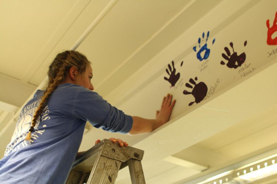 Senior Julia Karpilovsky leaves her mark on Niles West with her handprint. 