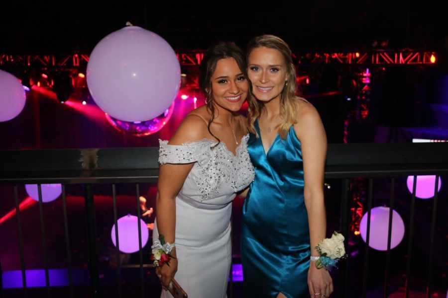 Nicole Hedean and Callieh Mohr taking a picture on the balcony at prom 2018