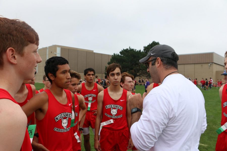 Varsity+talking+with+coach+before+their+first+race+of+the+season.