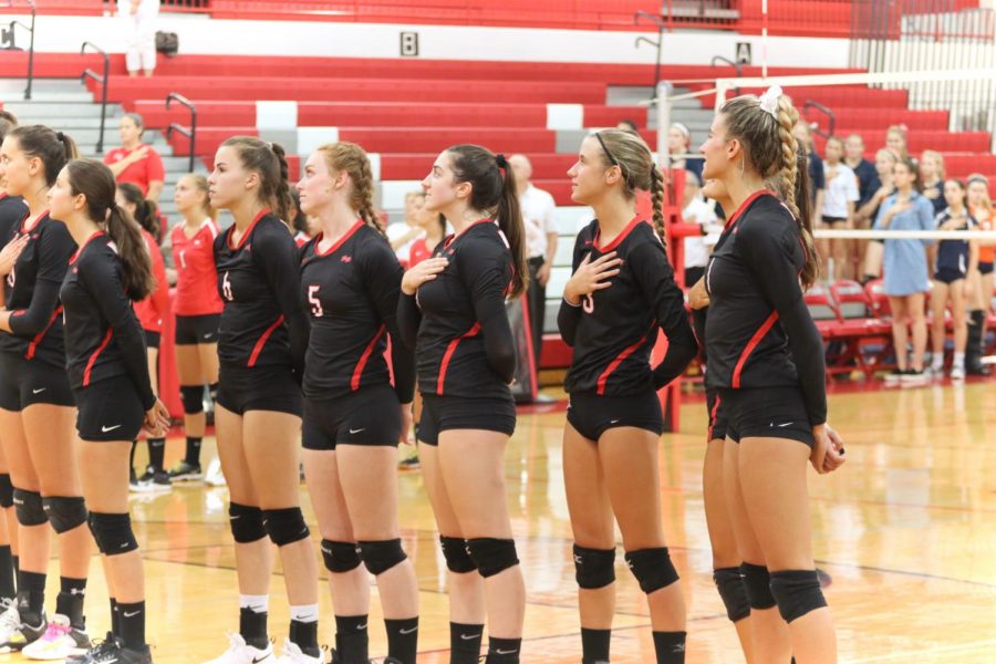 The Niles West Girls Volleyball team stands for the national anthem.