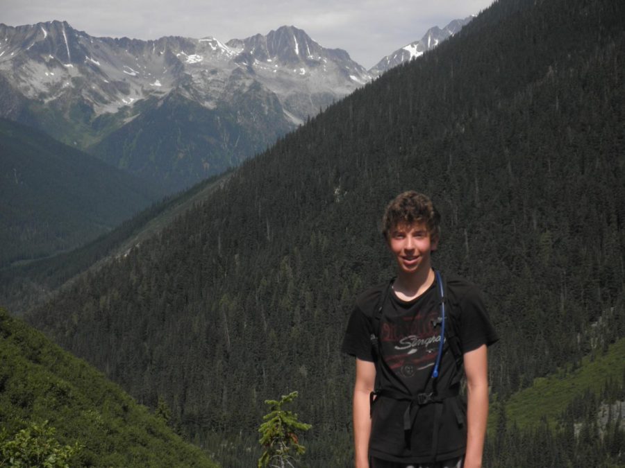 Senior Gabe Cohen posesfor a picture while on a hike in a mountain range.