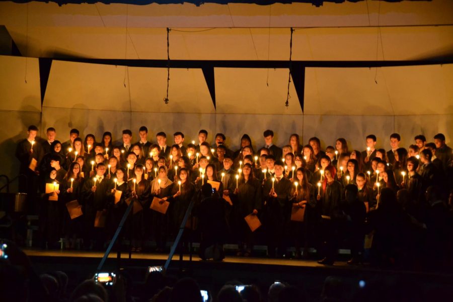 The NHS inductees lighting their candles on the stage and reciting the pledge.