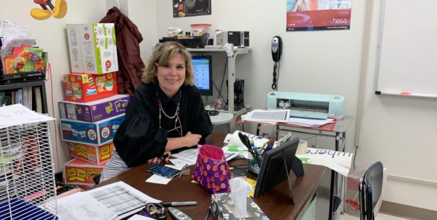 Mrs. Lisa Dunham posing at her desk during her fifth period Health Careers class.