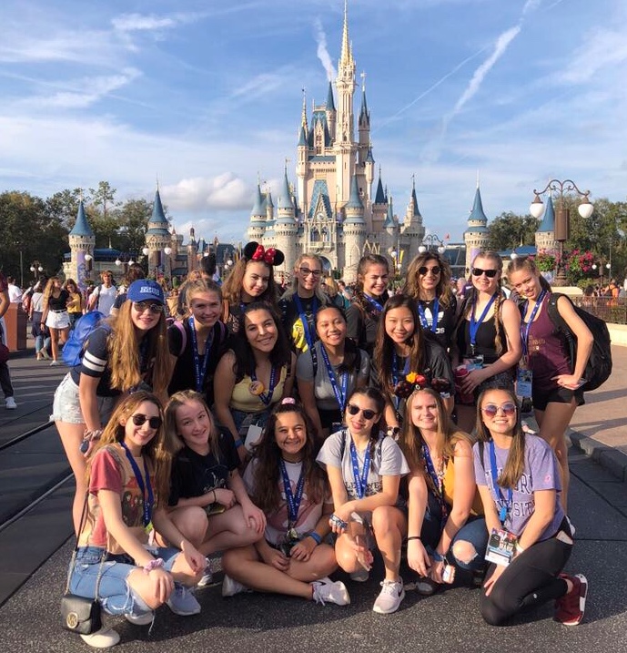 The Poms team posing in front of Cinderellas castle at Disney World. 