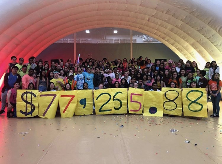Dance marathon members holding up the amount raised in donations of 2019 at the annual end of the year dance.
