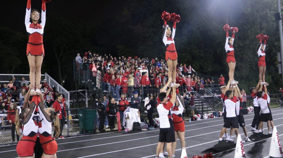 Niles West Varsity cheerleading hitting their stunts at the beginning of kick-off. 