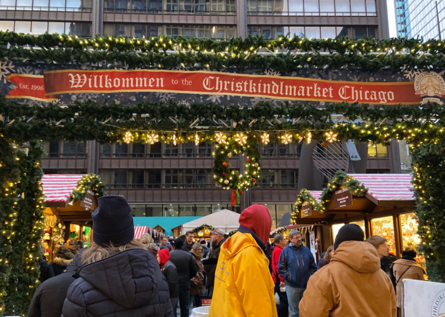 People entering the Christkindlmarket through the festive main entrance.