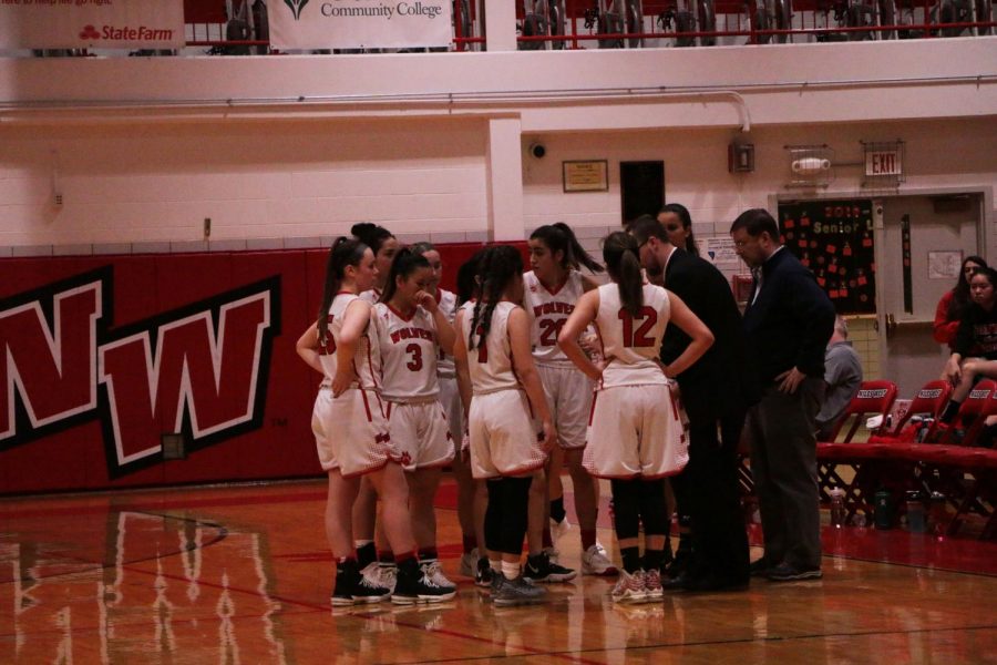Varsity+girls+basketball+huddling+together+during+a+timeout+to+discuss+their+strategy+to+win.+