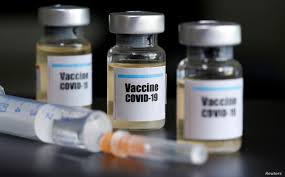 Small bottles with "Vaccine COVID-19" labels and a medical syringe via VOA News.