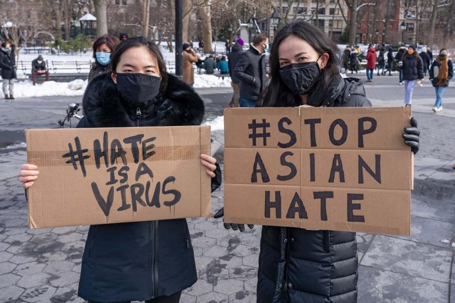 Two women stand and protest against Asian hate