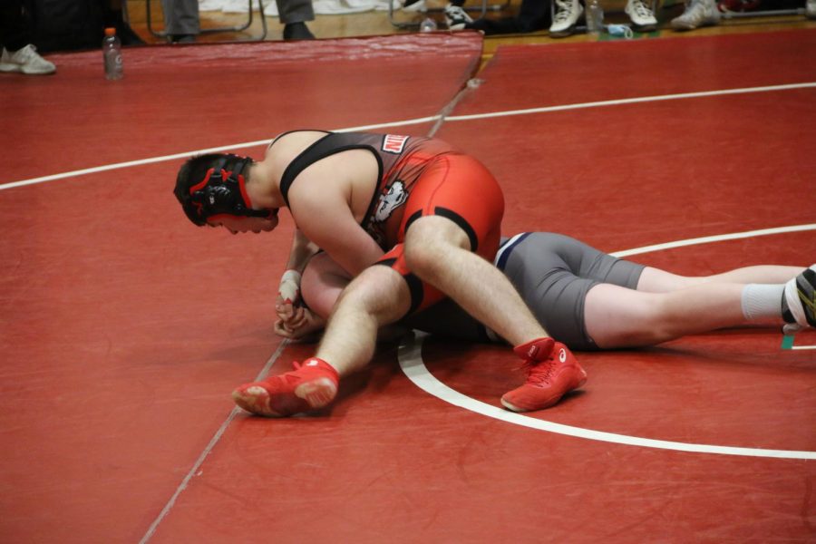 West wrestler on top of opponent, working for the pin.