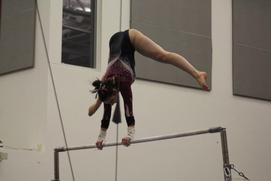 Stephanie Avram going into a handstand on the top of the bars