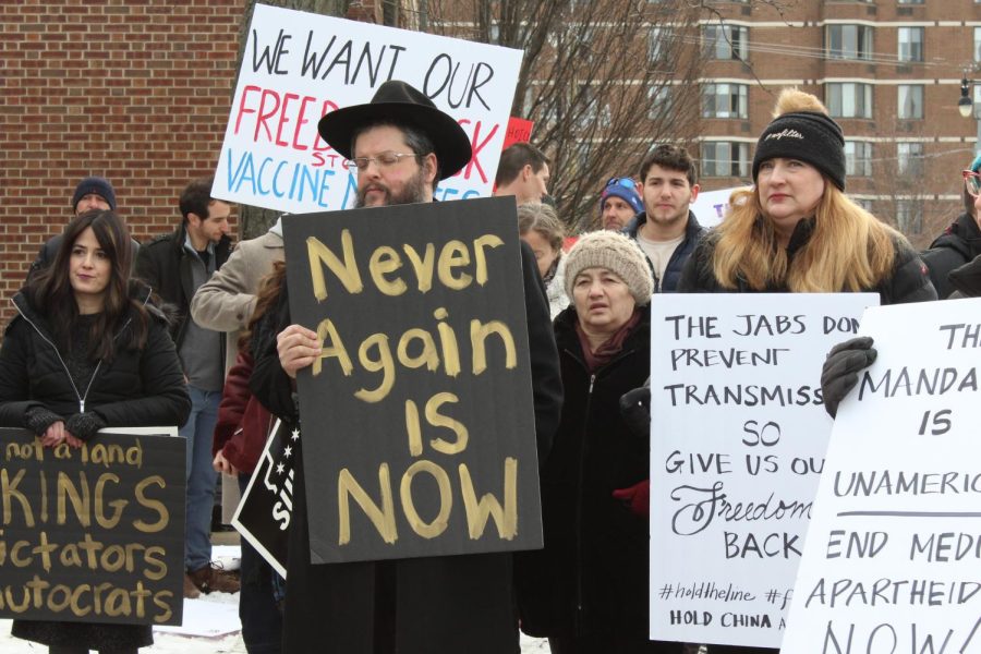 A local rabbi who spoke and chose not to disclose his name at the time of publishing with a sign that reads, Never again is now.