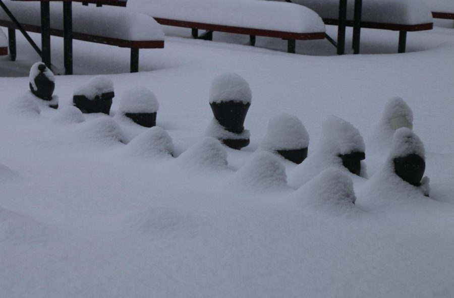 Chess pieces shivering  under the blanket of snow.