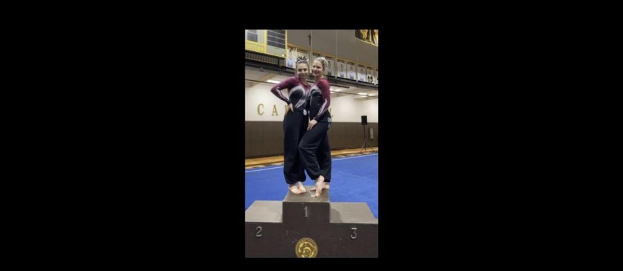 Sophomore Stephanie Avram (left) and senior Melanie Brill stand on the podium at the regionals gymnastics meet, celebrating their advancement to sectionals.