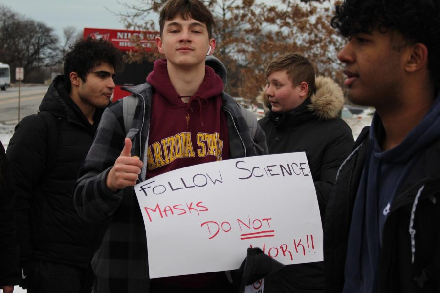 Junior David Ardelean, a strong participant in demonstration, showing his sign to those driving down Oakton Street. 