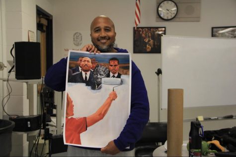 Calvin Terrell holding up a painting created by one of his good friend, Jonathan Harris. 