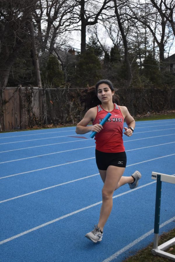 Melanie Sorisho eyes people on the sidelines while running the 8 by 400 relay race. 