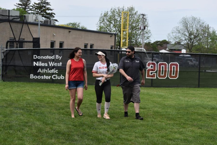 Emily Donovan laughs with her parents while walking up to the plate.