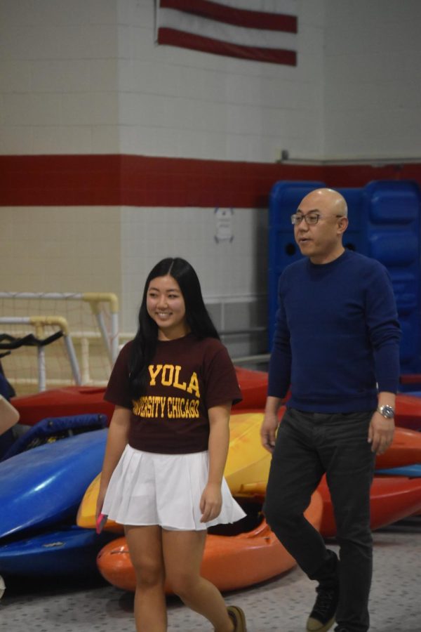 Emily Suh walks with her father to go take pictures for her senior night. 