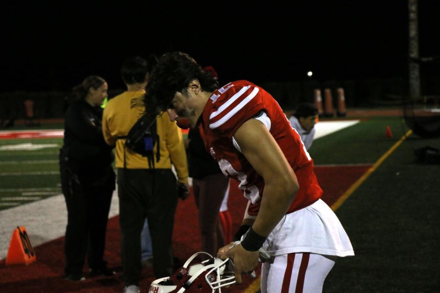 Player Christian Guzman putting on his helmet, getting ready to play.