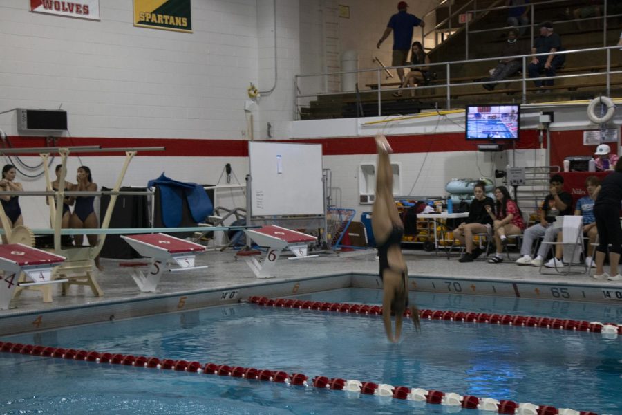 Senior Natalia Garcia enters the water as she completes her dive. 