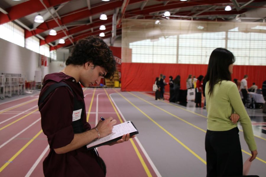 Senior Gabriel Daoud takes notes while waiting for available college representative.  