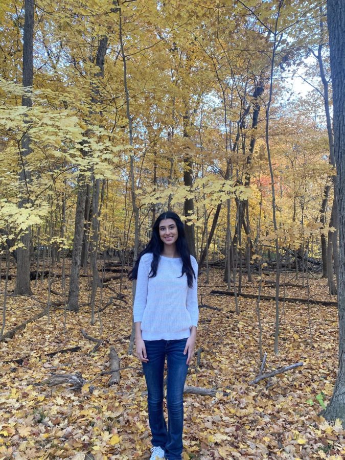 Senior Prisha Singh poses in front of fall foliage. 