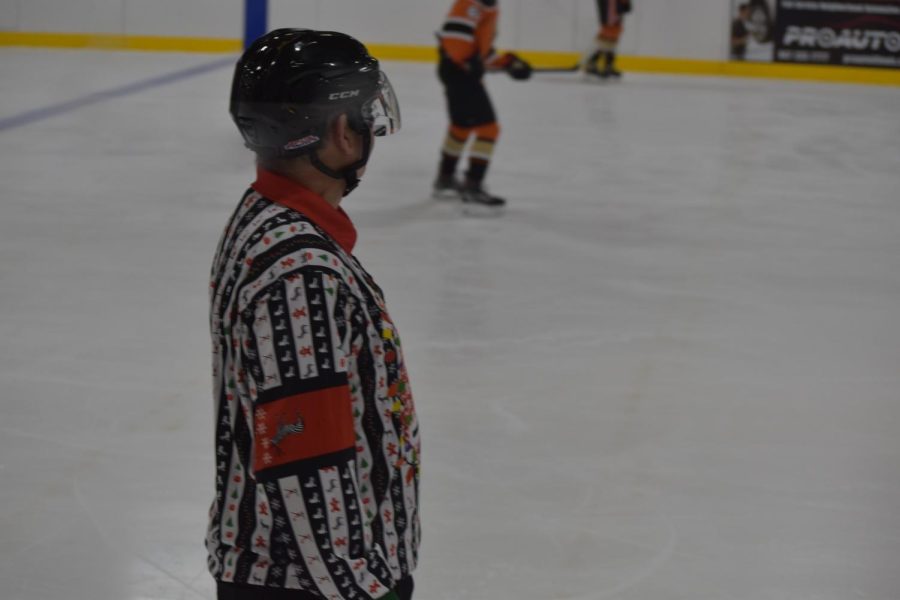 Referee wears holiday themed uniform, playing close attention to the game. 