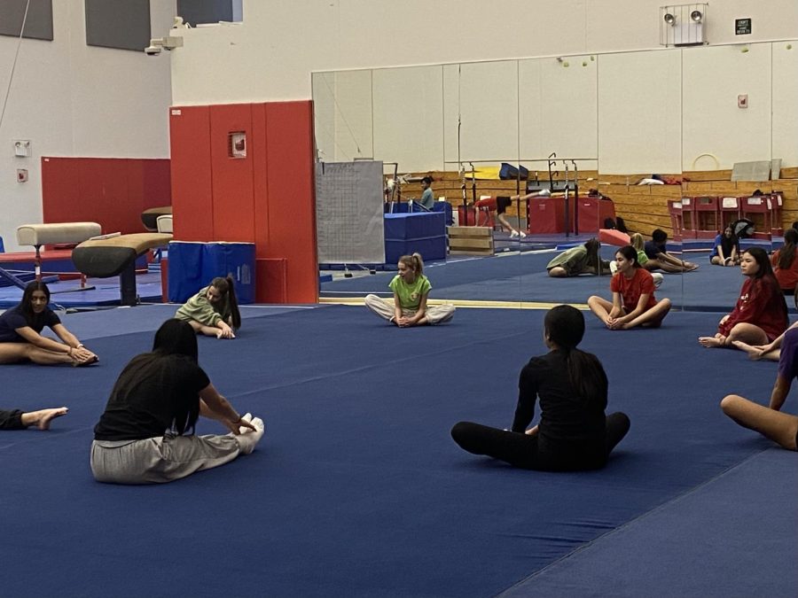 Gymnastic girls stretching before their practice.