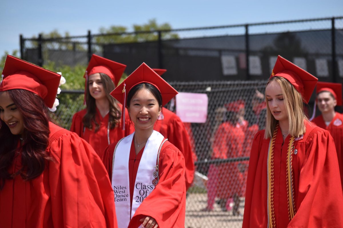 Graduate, Bridgit Bui smiles at the camera as she walks into her graduation ceremony. 