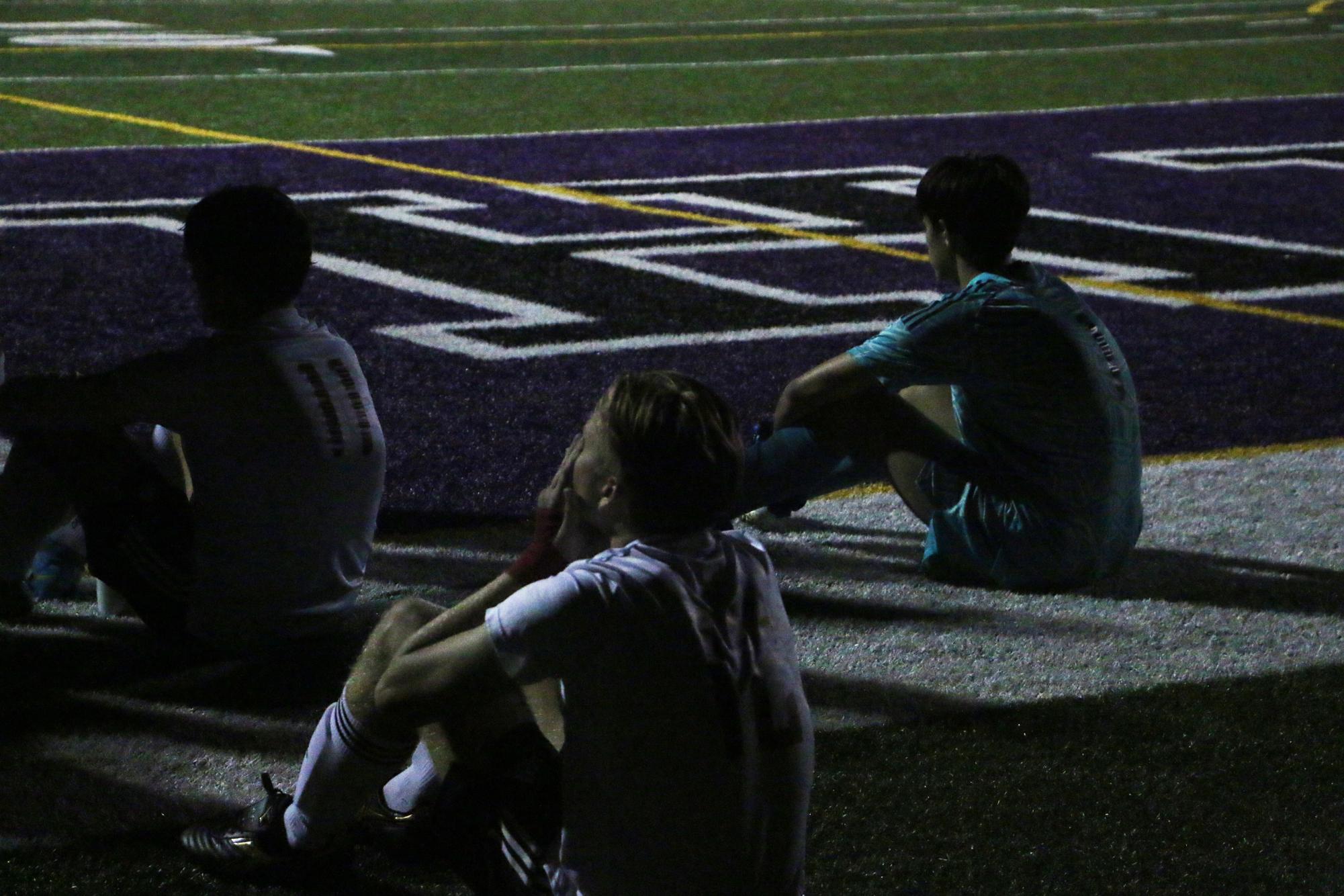 West players refocus before the second half as they sit on the turf. 