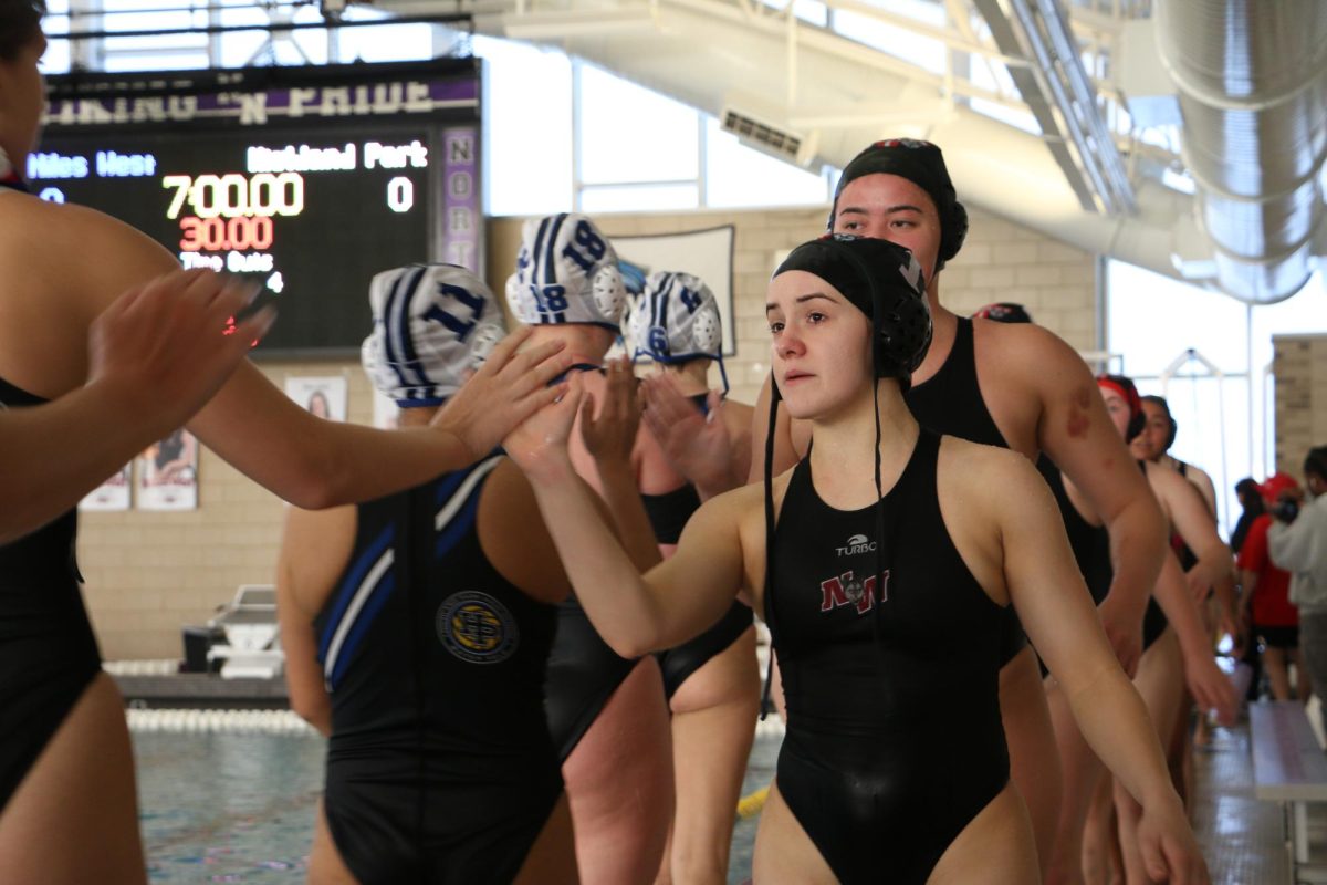 Niles West water polo girls wish a good game to their opponents after defeating them 