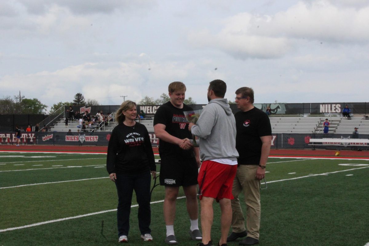 Shot put and Discus athlete, senior Aidan Sebastian takes one last handshake with his coach. 