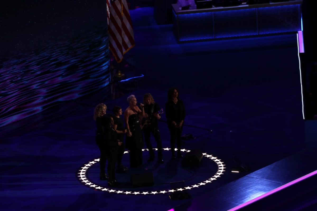 Pink and her daughter perform "What About Us" onstage accompanied by musicians.