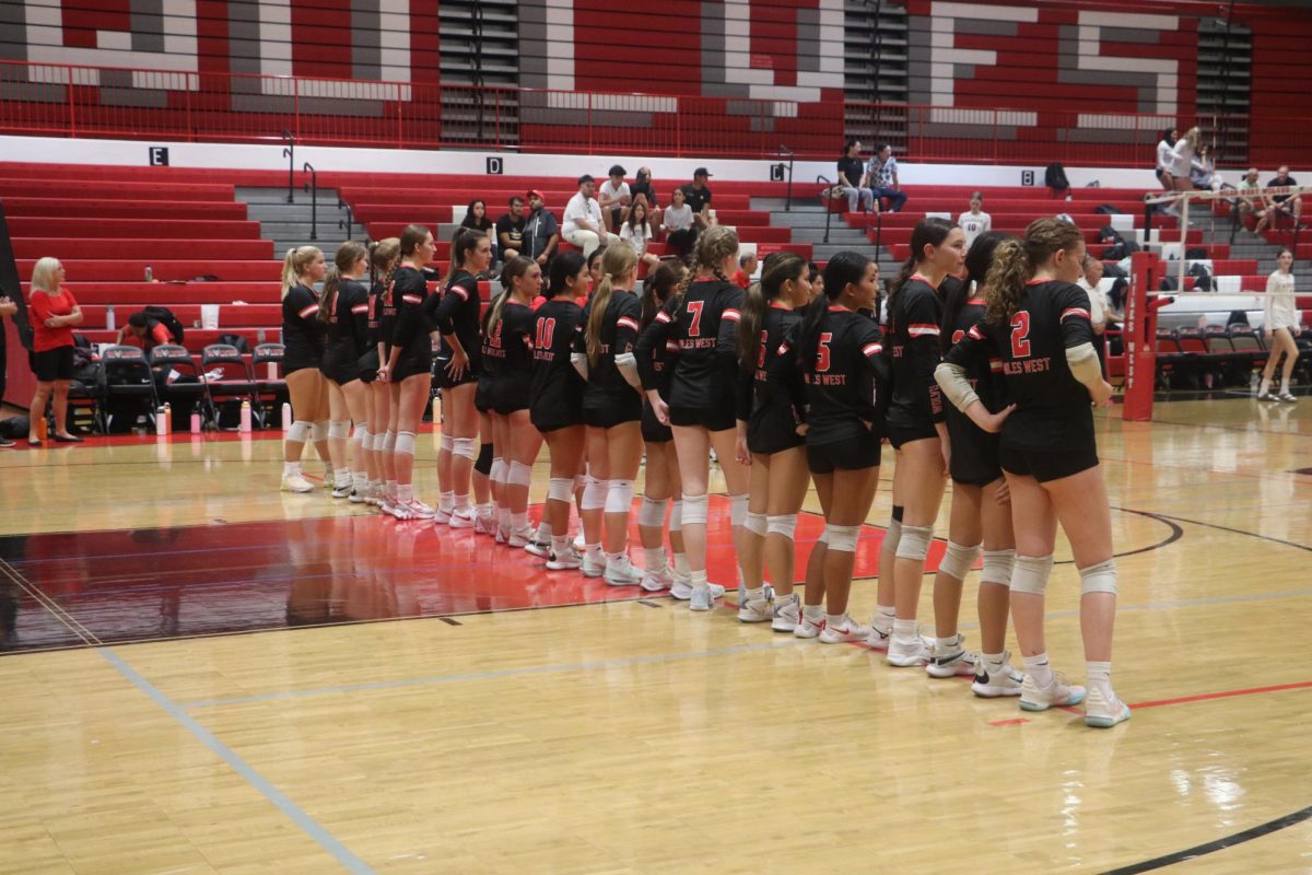 The girls stand while the opposing team's line up is announced. 