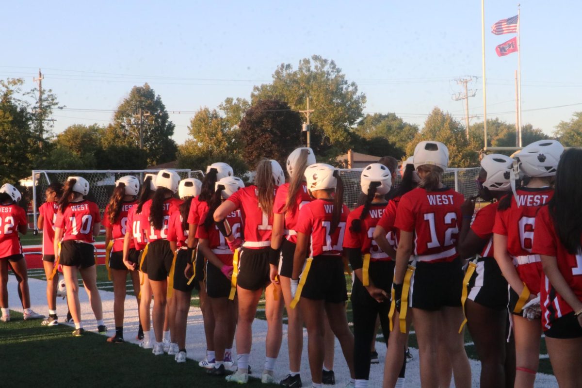 The team rises for the National Anthem.