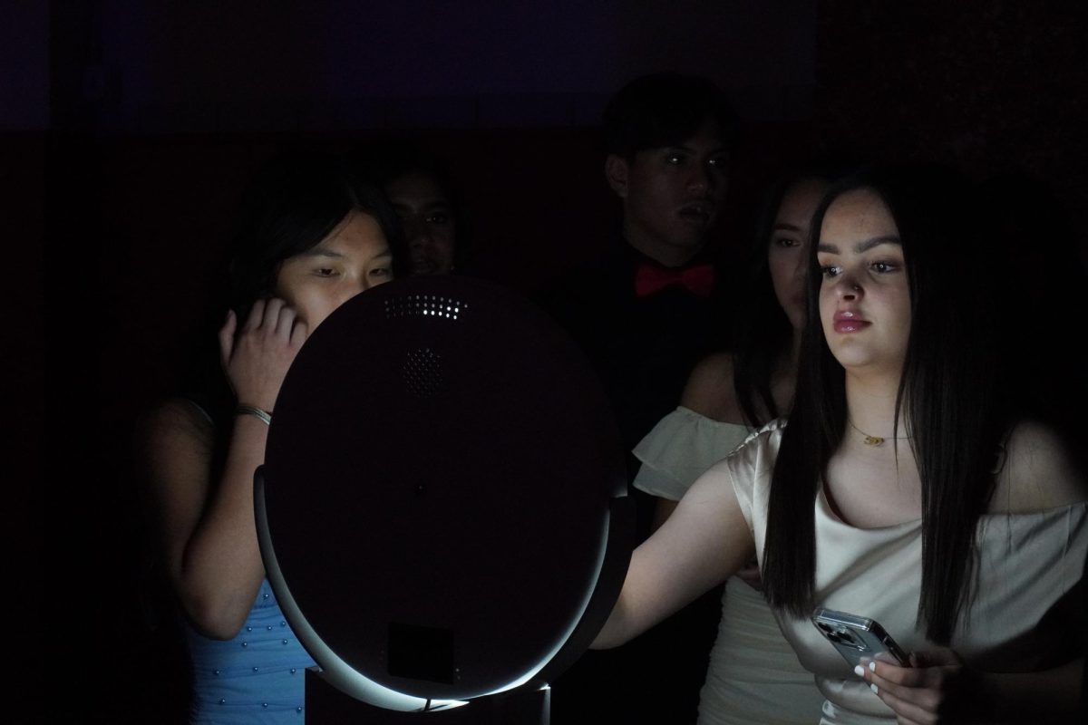 Junior Maryam Safdary looks at their photos after posing for them in the contest gym. 