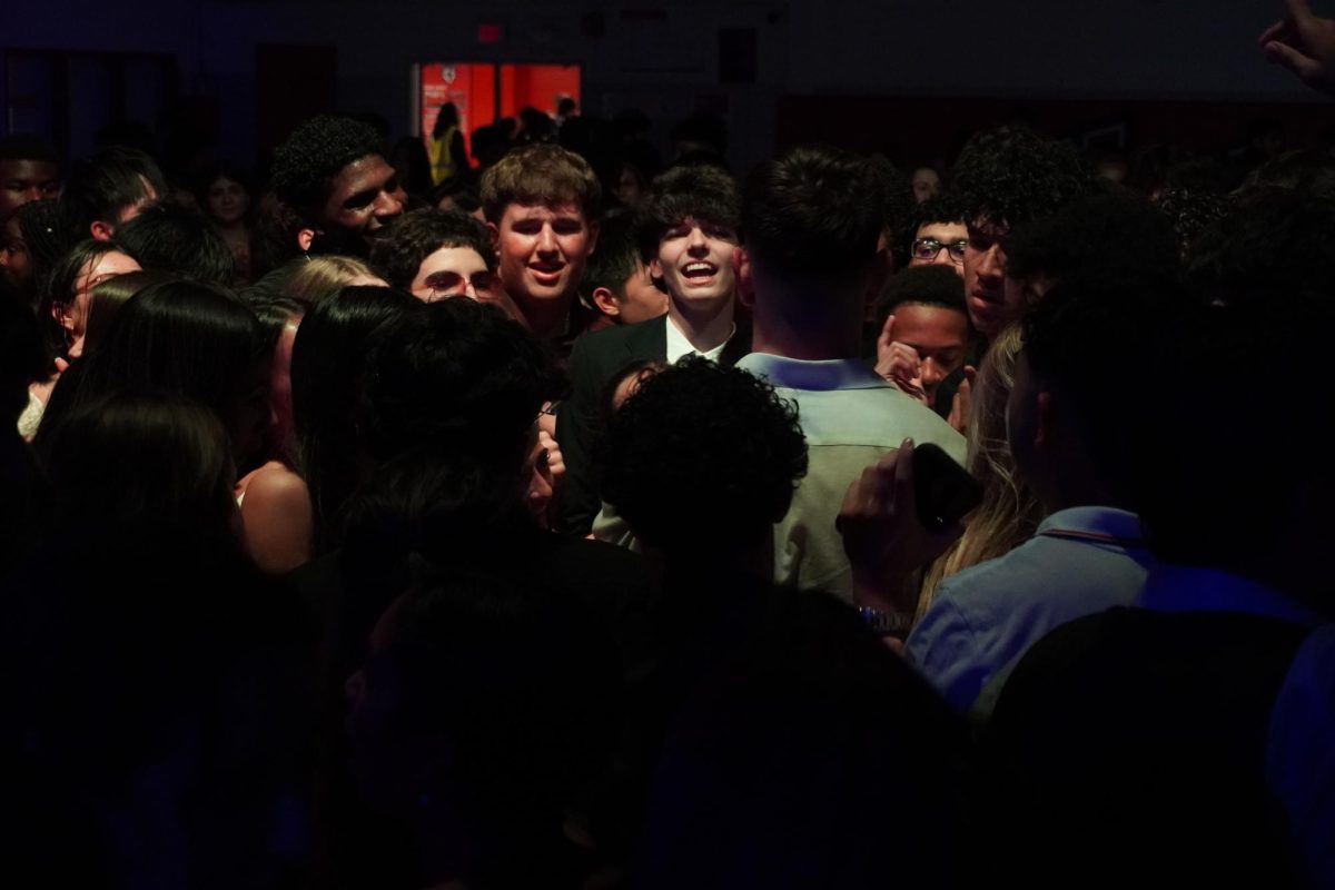 Students form a mosh pit while the music is played by the DJ.