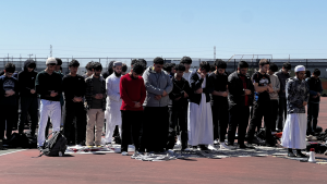 Students from the Muslim Student Association (MSA) pray together on prayer mats on the Niles West tennis courts.  They are facing the direction of the Kaaba, a place of worship located in Mecca, Saudi Arabia.  MSA meets Friday afternoons for prayer and discussion.