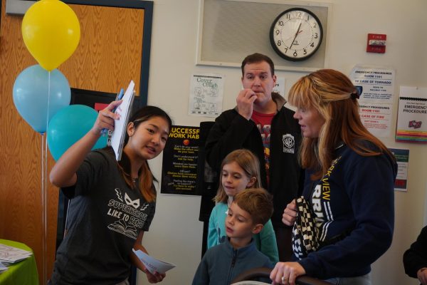 Senior Chanikarn Ganlayanapong guides families into the lit center where a variety of stations are being held. 