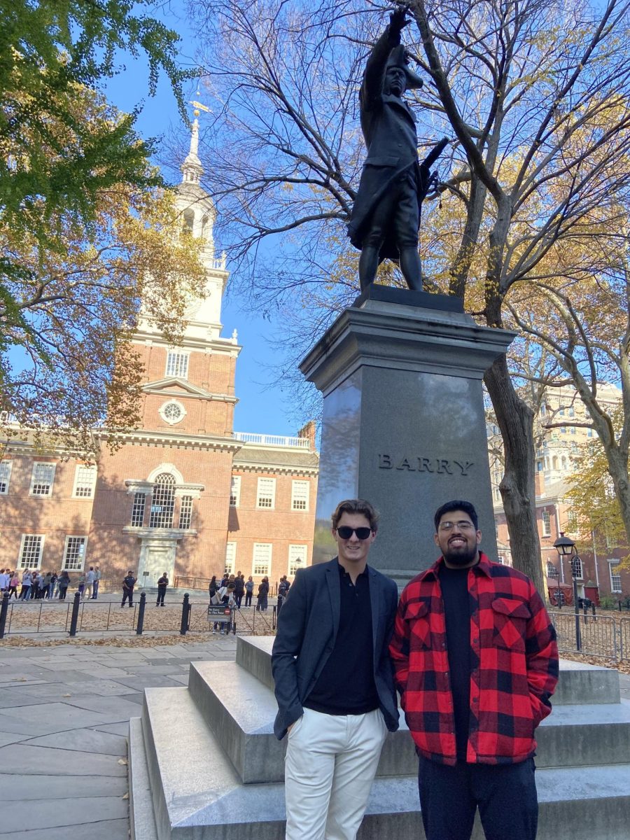 From left, seniors Luka Cejovic and Ibrahim Quadri, pose in front of a statue of Commodore John Barry.