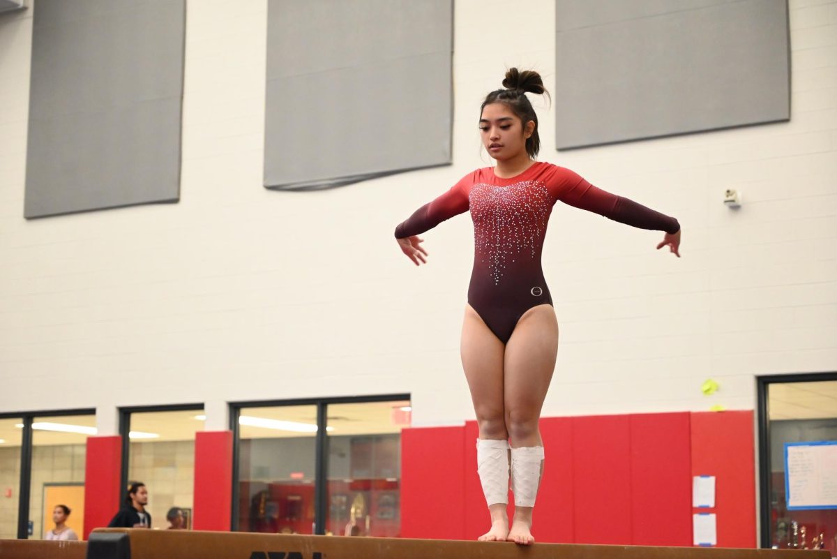 Hadiyalah Bongcawil, sophomore, prepares to perform a trick during her beam routine. 